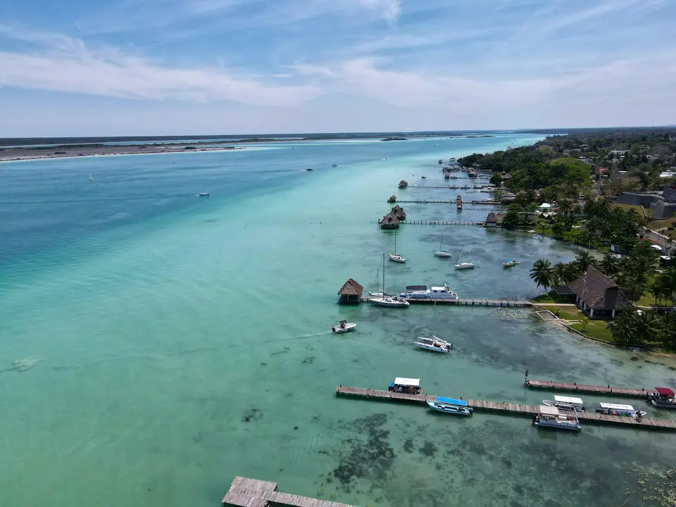 a body of water with boats and buildings along it — Bacalar