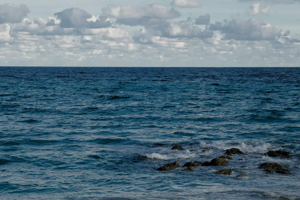 a large body of water with rocks in the foreground — Cozumel