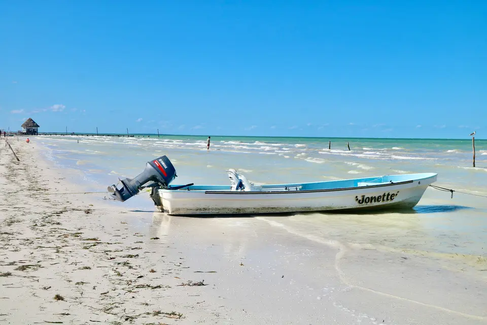 white and blue boat on beach during daytime — Holbox