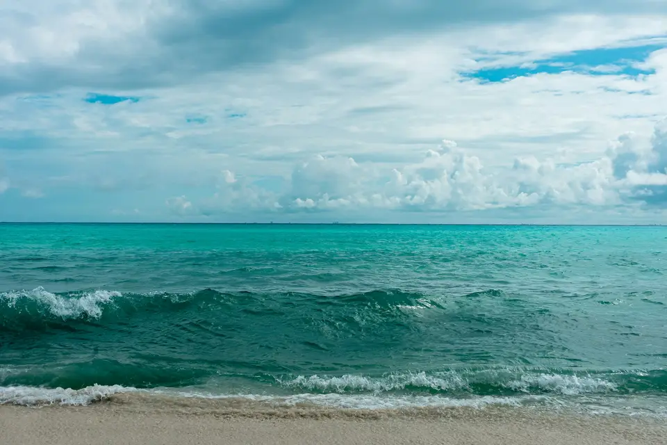 blue sea under blue sky and white clouds during daytime — Holbox
