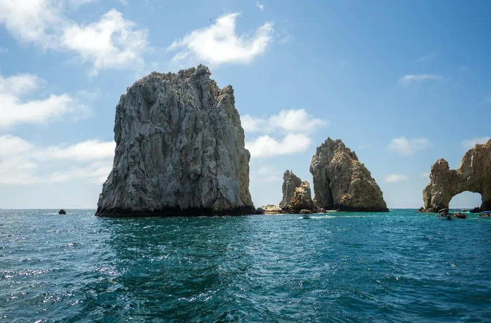 Rocky sea stacks under a blue sky with clouds — Los Cabos