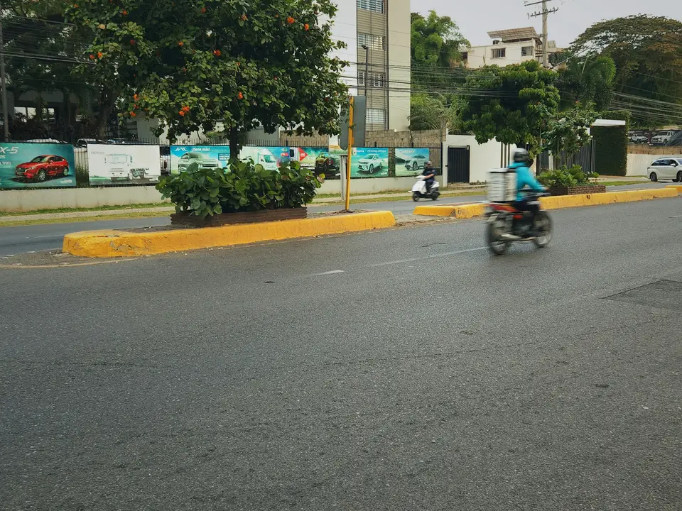 Motorcyclist rides down a wet city street — Mérida