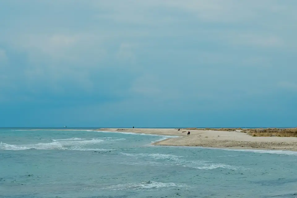 Waves gently lap a sandy beach under a cloudy sky — Playa del Carmen