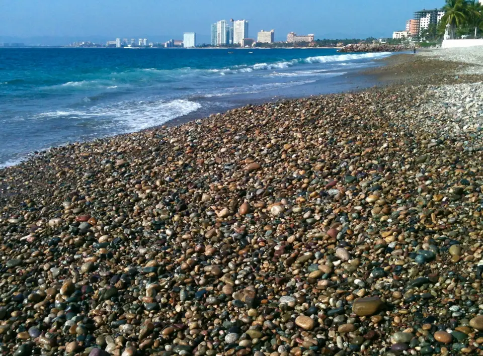 a rocky beach with a city in the background — Puerto Vallarta