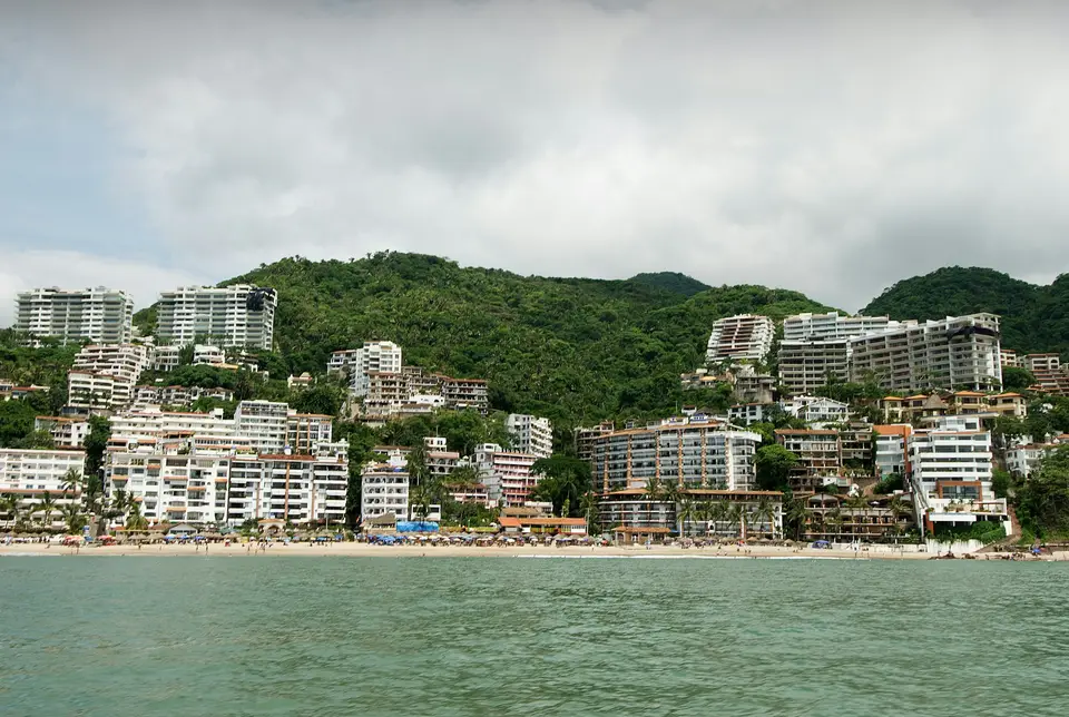 Beachfront buildings nestled against a lush hillside — Puerto Vallarta