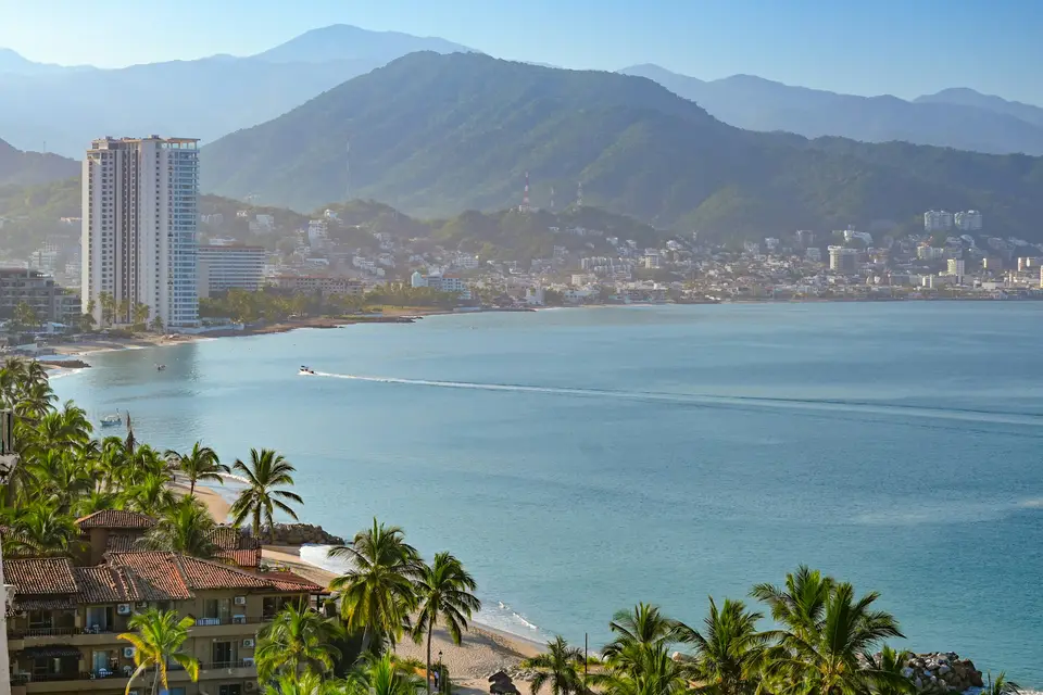 A view of a beach with a city in the background — Puerto Vallarta