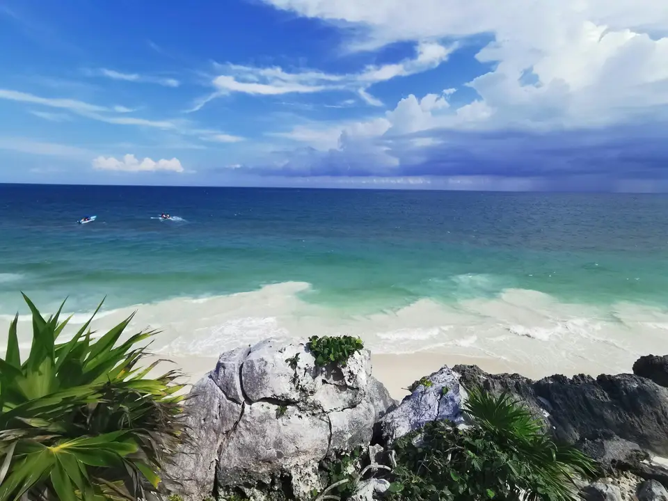 a rocky beach with a body of water in the background — Tulum